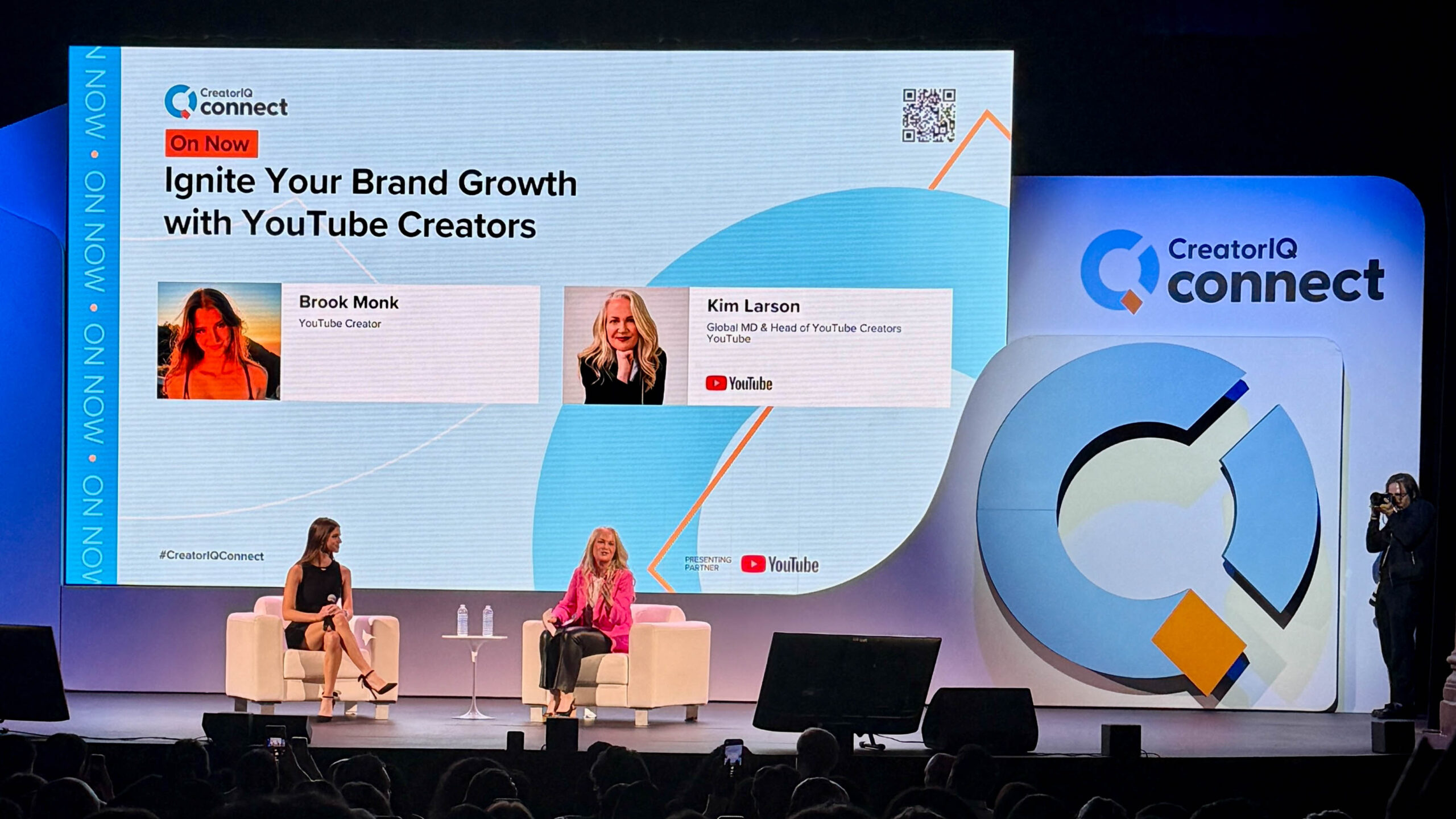 Two speakers on stage with a large screen that reads: "Ignite Your Brand Growth with Youtube Creators" and Brook Monk - YouTube Creator, Kim Larson - Global MD and Head of YouTube Creators Youtube.