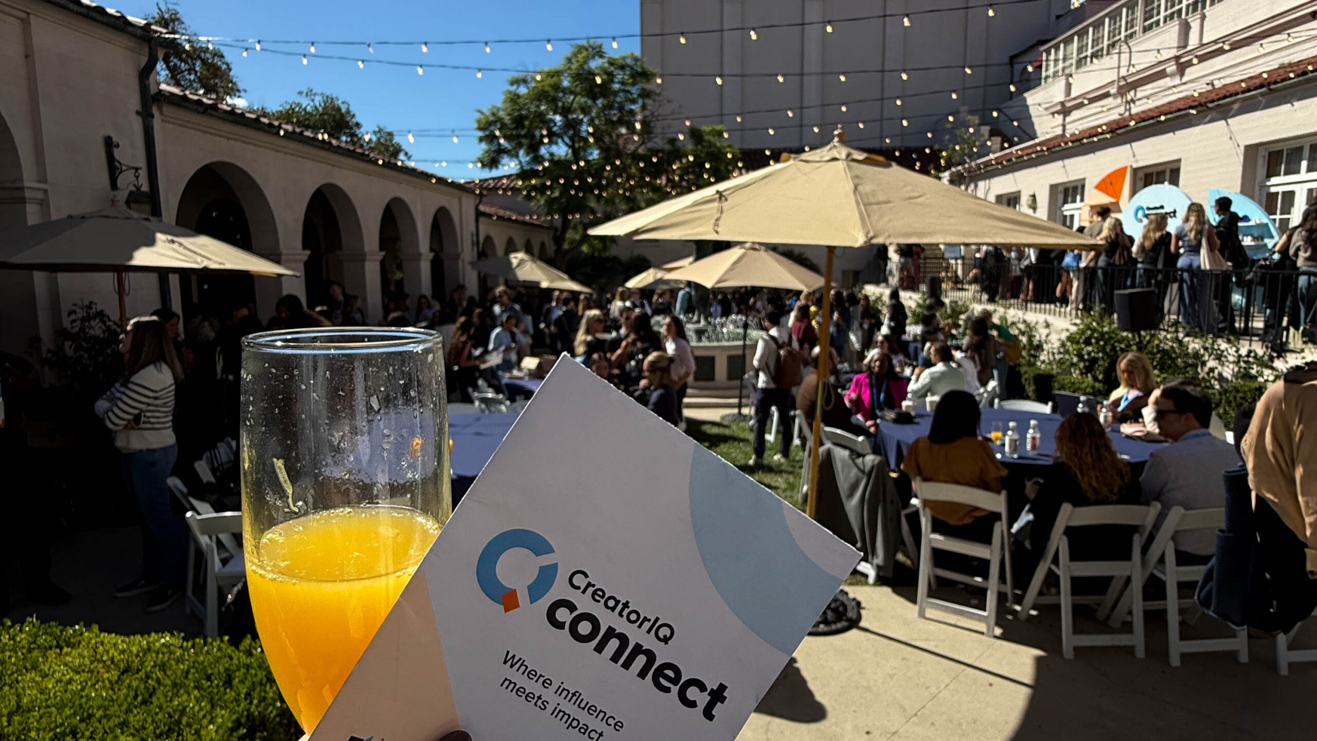 A pamphlet in the foreground for CreatorIQ Connect with the outdoor part of the venue seen in the background.