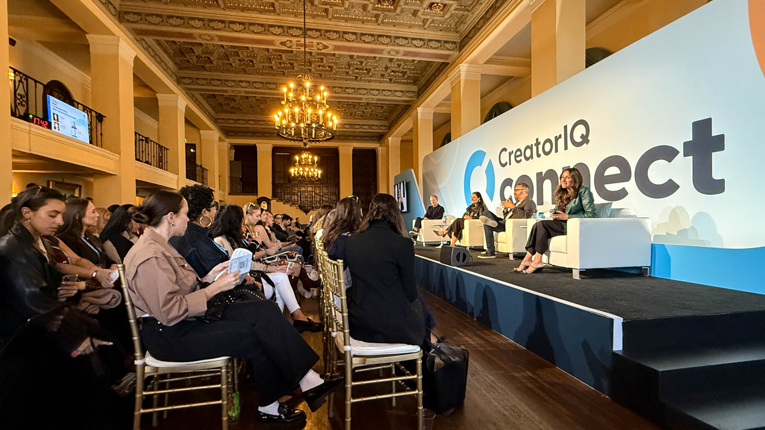 4 speakers sitting on a stage in front of a small crowd at CreatorIQ Connect.