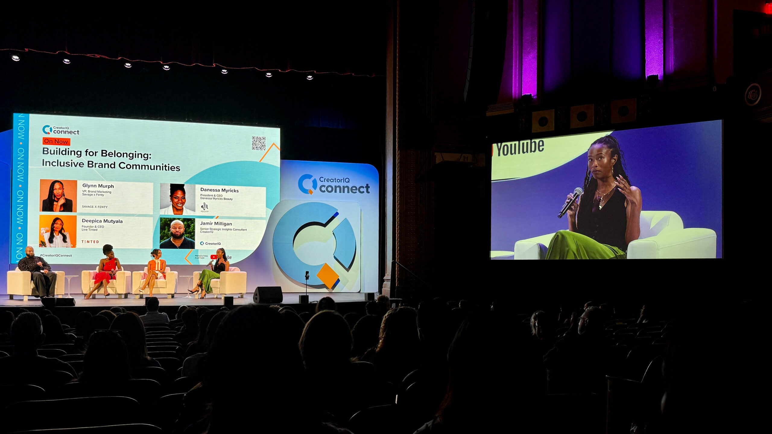 4 speakers presenting on stage to a large audience. The speakers named on the large screen include: Glynn Murph - VP, Brand Marketing for Savage x Fenty, Deepica Mutyala - Founder and CEO of Live Tinted, Danessa Myricks - President and CEO of Danessa Myricks Beauty and Jamir Milligan - Senior Strategic Insights Consultant for CreatorIQ