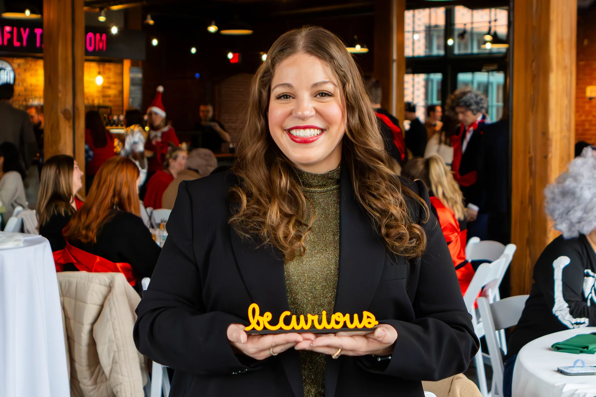 Kristen Kaestner holding the "Be Curious" award.