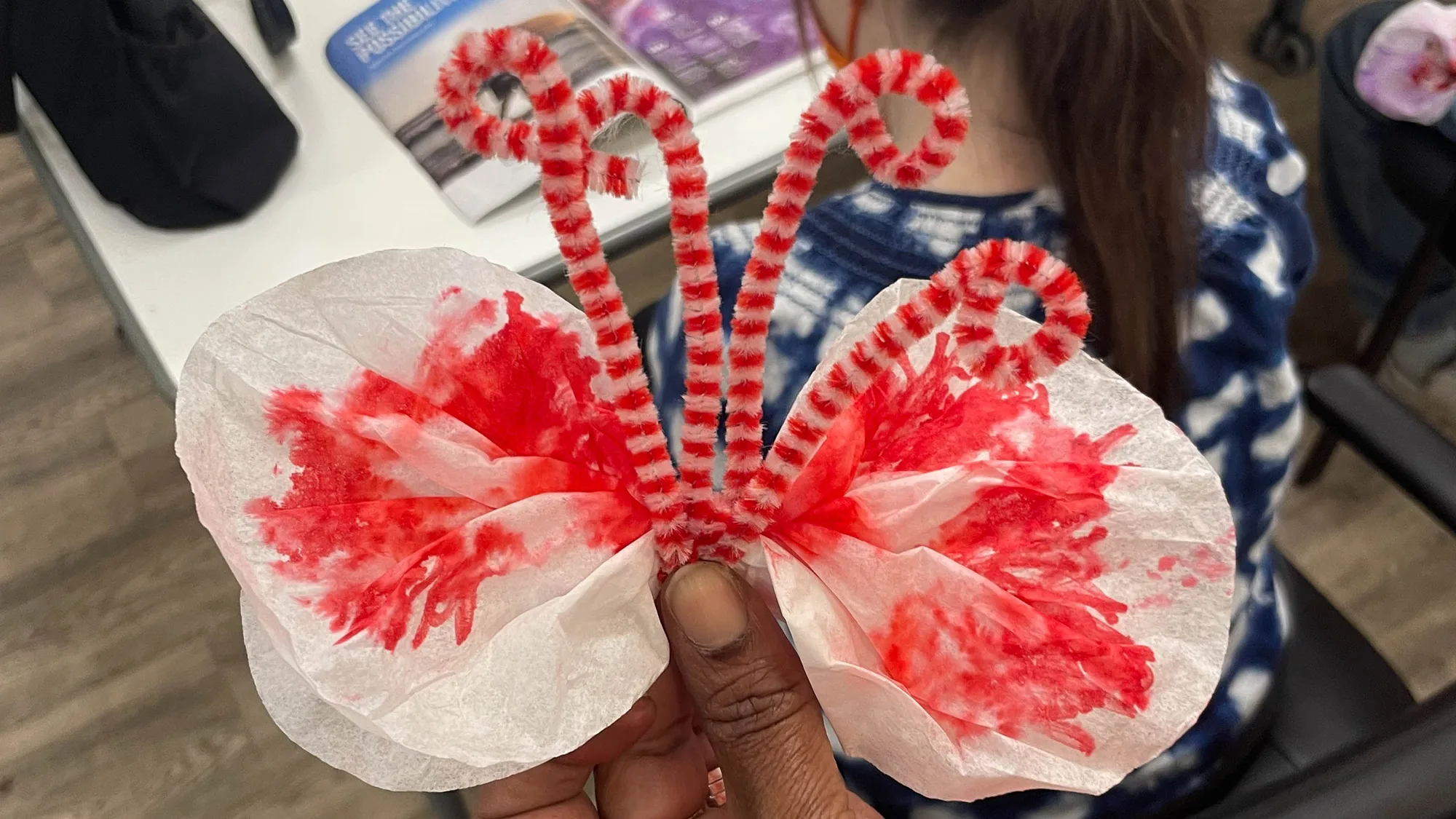 An HLK volunteer seen at St. Louis Arc’s Aging with Empowerment program making a craft made of pipe cleaners and tissue paper.